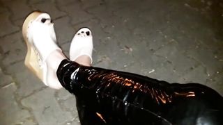 crossdresser on the street in spandex stretch pants and high high-heeled shoes