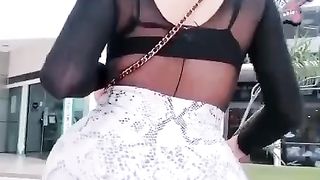 she-male nymph in a public square demonstrating her rump to those who pass assfucking