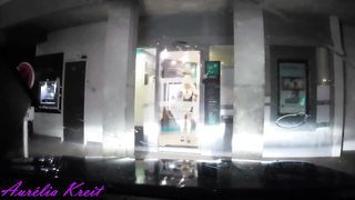 maid clothed under translucent raincoat to cash dipenser