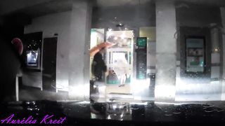 maid clothed under translucent raincoat to cash dipenser