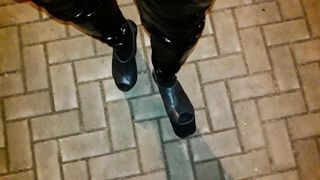 a crossdresser in high ram platform footwear and spandex stretch pants is ambling the streets at night