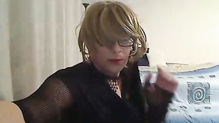 ultra-kinky COUGAR t-model demonstrating off and finger-banging in front of web cam in black fishnet and brief sundress and high stilettos