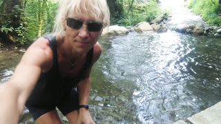 Alexa Cosmic trans doll swimming in font near waterfall dressed in cut-offs and t-tee-shirt...