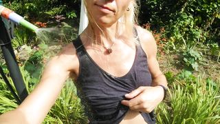 Refreshing & soaking t-t-shirt and black cut-offs in hose pipe in the garden...