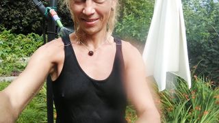 Refreshing & soaking t-t-shirt and black cut-offs in hose pipe in the garden...