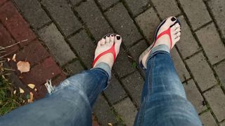 a crossdresser with magnificent soles in spin flops is provocative on the street