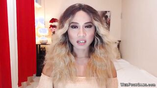 Asain blonde TS wanks cock in chair in front of webcam